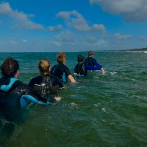 des marcheurs en combinaison de plongée dans l'eau de mer pratiquent le longe cote, la marche aquatique